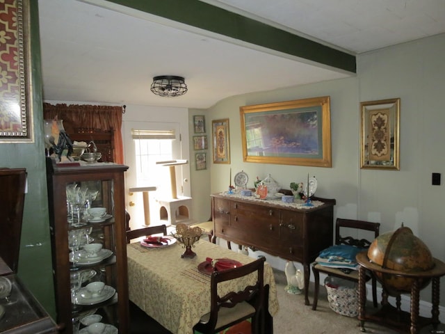 dining area with beamed ceiling and carpet floors