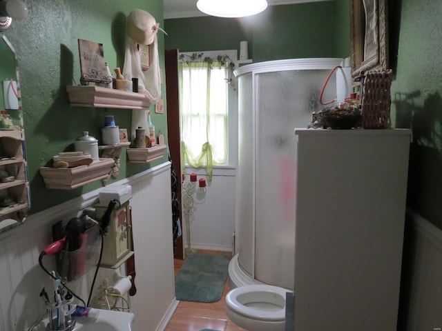 bathroom with toilet, an enclosed shower, wood-type flooring, and crown molding