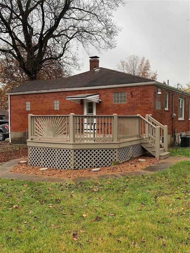 rear view of house with central AC, a yard, and a deck