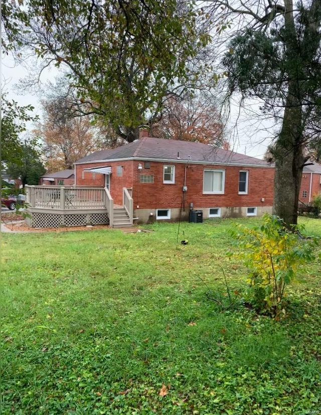 rear view of house with a lawn, central AC unit, and a deck