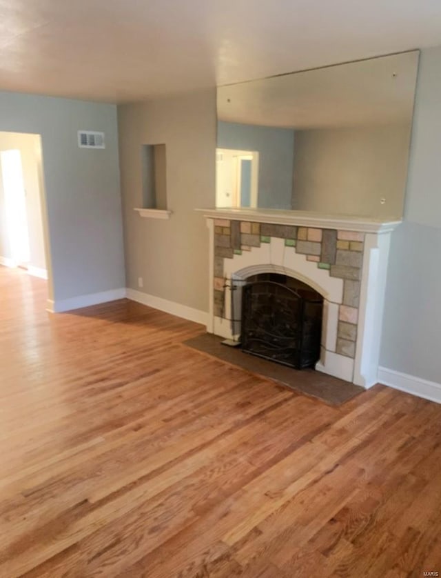 unfurnished living room with hardwood / wood-style flooring and a fireplace