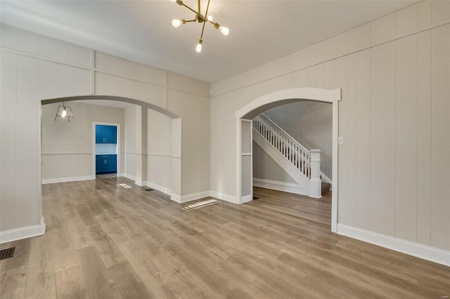 unfurnished room featuring wood walls and wood-type flooring