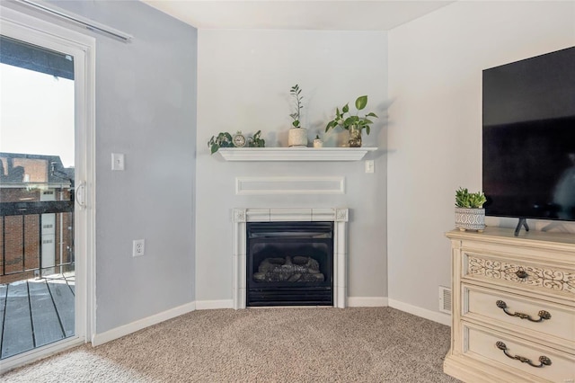 living room featuring carpet and a tile fireplace