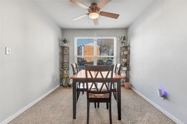 carpeted dining area with ceiling fan