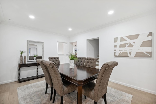 dining room with light hardwood / wood-style floors and ornamental molding