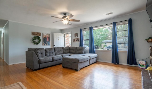 living room featuring hardwood / wood-style floors, ceiling fan, and ornamental molding