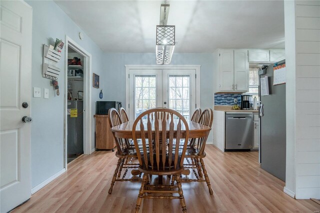 dining space with french doors and light hardwood / wood-style floors