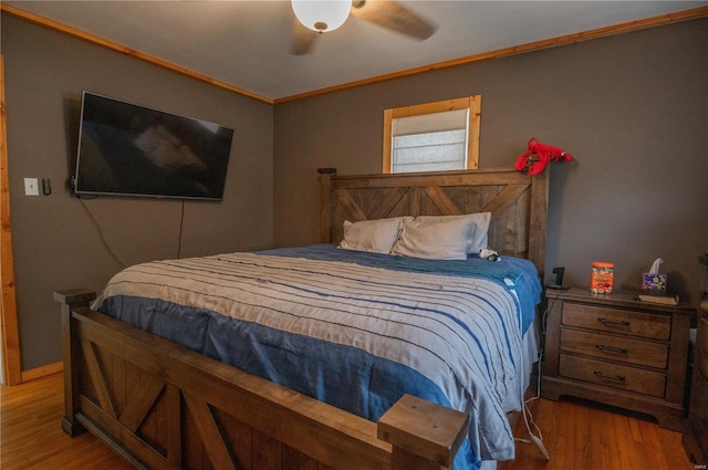 bedroom featuring light hardwood / wood-style floors, ceiling fan, and crown molding