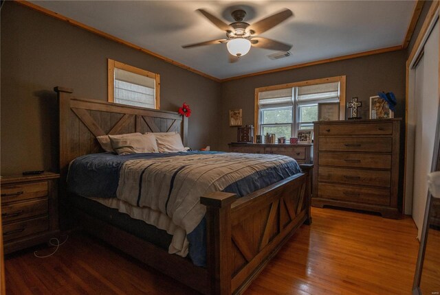 bedroom with ceiling fan, crown molding, and wood-type flooring