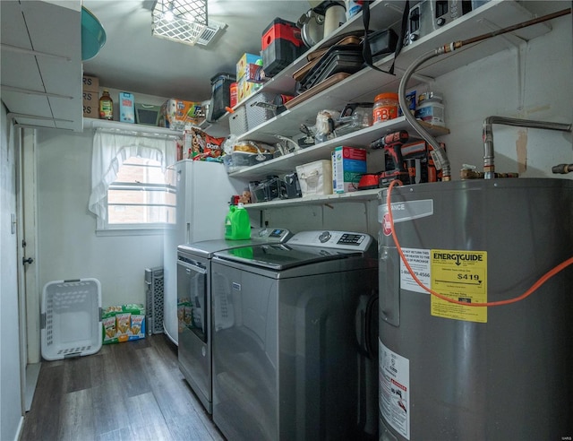 washroom with electric water heater, separate washer and dryer, and hardwood / wood-style flooring