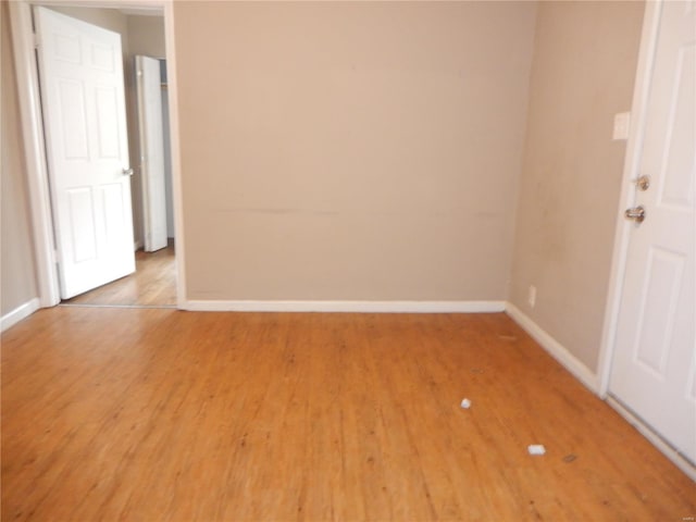 spare room with baseboards and light wood-style floors