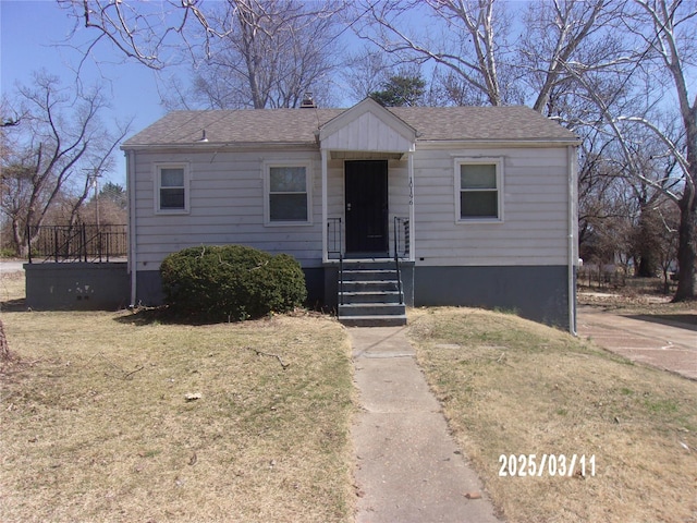 bungalow-style home featuring a front lawn and a shingled roof