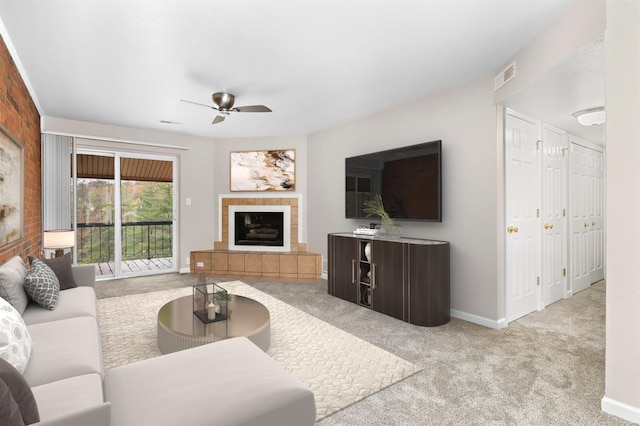 carpeted living room featuring ceiling fan and a tiled fireplace