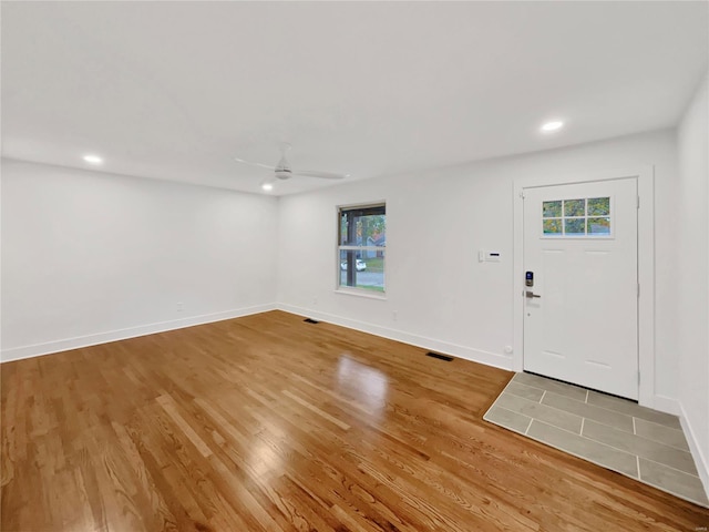 foyer entrance featuring hardwood / wood-style floors, a wealth of natural light, and ceiling fan