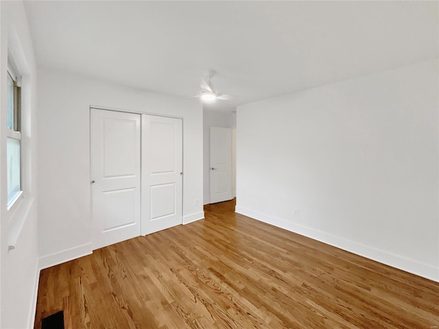 unfurnished bedroom featuring hardwood / wood-style flooring, ceiling fan, and a closet