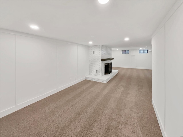 unfurnished living room featuring carpet flooring and a brick fireplace