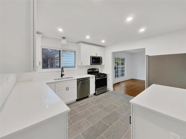 kitchen featuring white cabinetry, sink, light hardwood / wood-style flooring, and appliances with stainless steel finishes