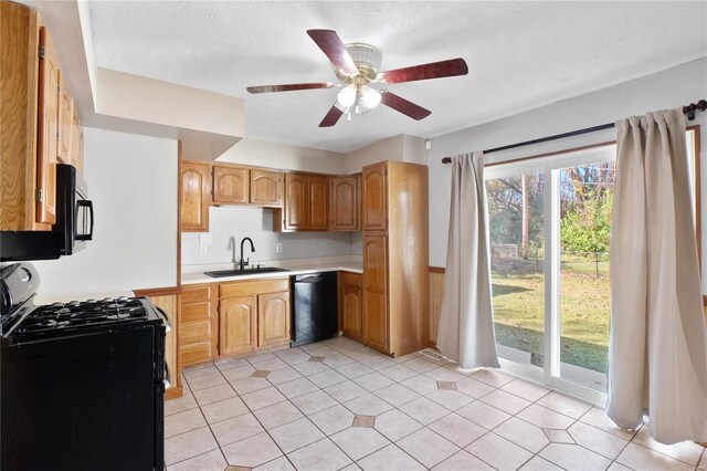 kitchen featuring black appliances, sink, ceiling fan, light tile patterned floors, and a textured ceiling