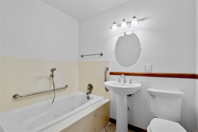 bathroom with a tub, sink, tile patterned flooring, and toilet