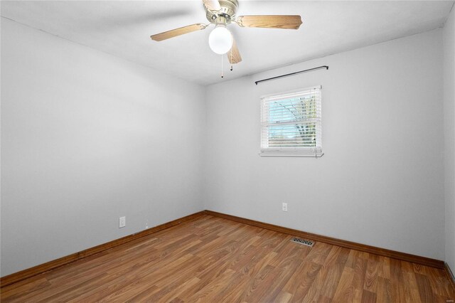 empty room with hardwood / wood-style floors and ceiling fan