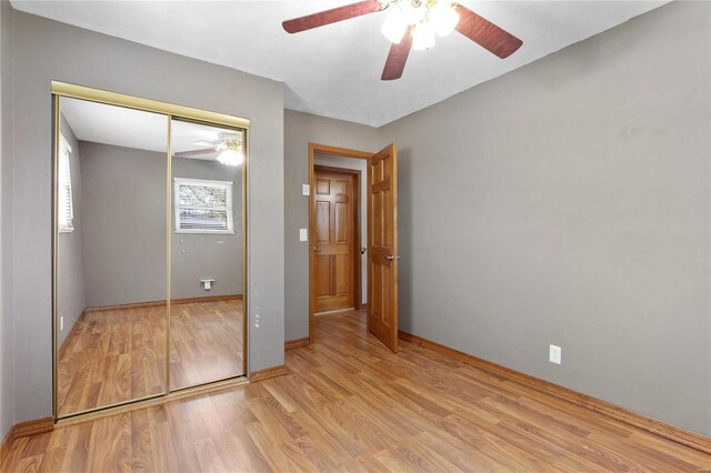 unfurnished bedroom featuring a closet, light hardwood / wood-style flooring, and ceiling fan