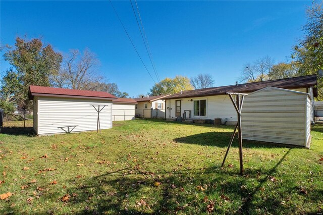 back of property with a lawn and a storage shed