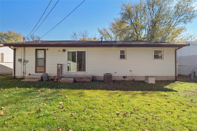 rear view of property with a lawn and central AC