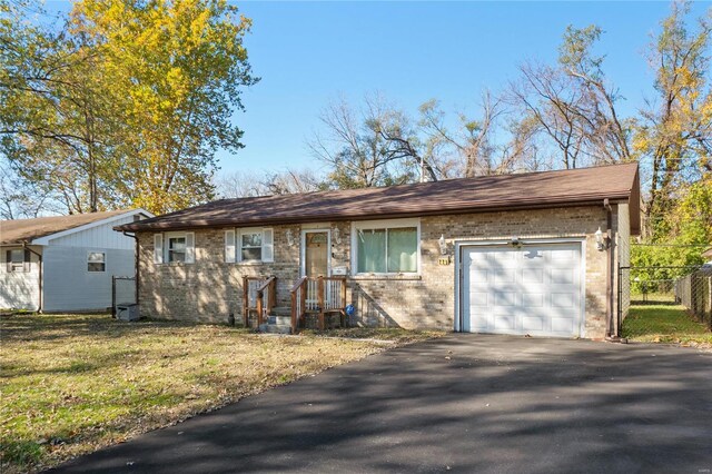 single story home featuring a front lawn and a garage