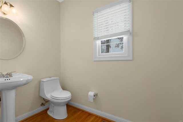 bathroom featuring toilet, hardwood / wood-style flooring, and sink