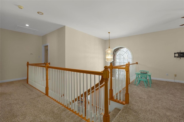 corridor featuring carpet flooring and an inviting chandelier