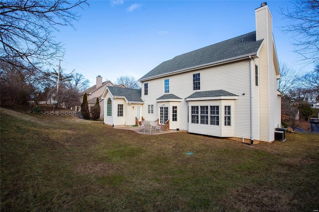 back of property featuring a patio area, a yard, and central AC