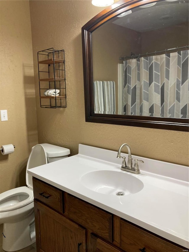 bathroom with a shower with curtain, vanity, and toilet