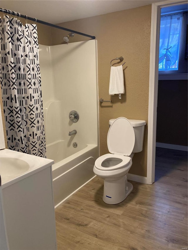 full bathroom featuring hardwood / wood-style flooring, vanity, toilet, and shower / bath combo with shower curtain