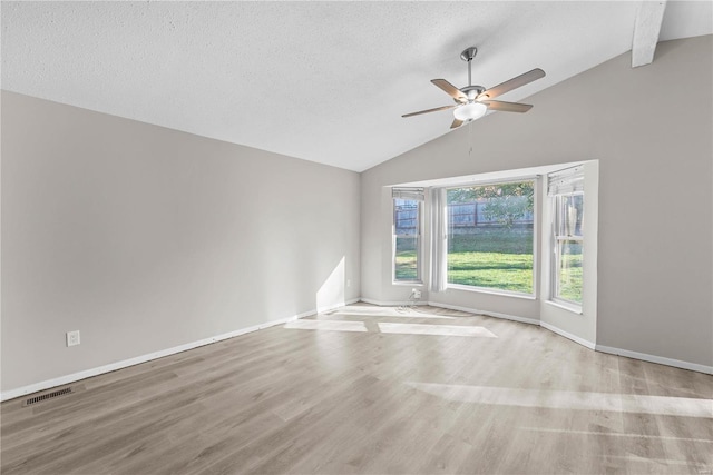 empty room featuring vaulted ceiling with beams, light wood-type flooring, a textured ceiling, and ceiling fan