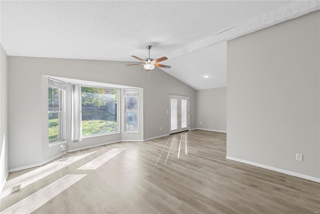 unfurnished living room featuring ceiling fan, light hardwood / wood-style floors, lofted ceiling, and a textured ceiling