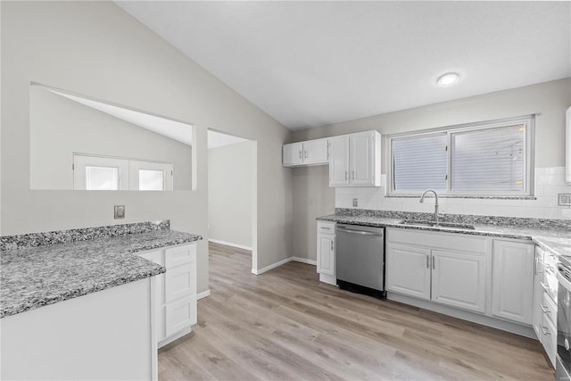 kitchen featuring light stone countertops, appliances with stainless steel finishes, white cabinetry, and sink