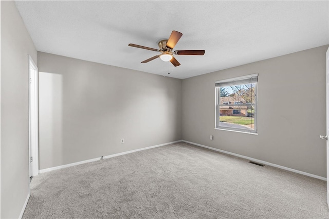 carpeted spare room with ceiling fan and a textured ceiling