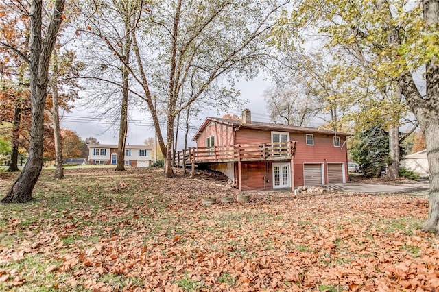 back of property featuring a garage and a wooden deck