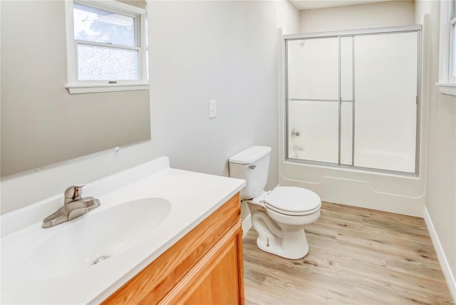 full bathroom with wood-type flooring, vanity, toilet, and enclosed tub / shower combo