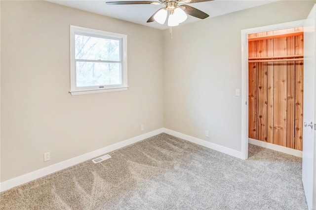 unfurnished bedroom featuring ceiling fan, a closet, and carpet