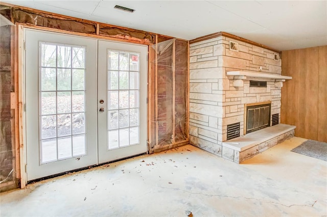 entryway featuring a stone fireplace and french doors