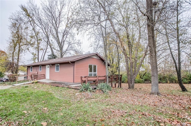 view of side of home featuring a deck and a yard