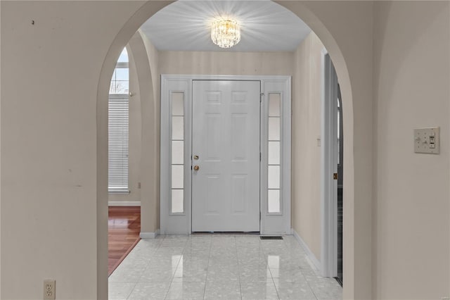 foyer with light hardwood / wood-style flooring and a chandelier