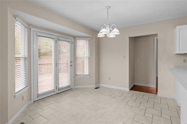 unfurnished dining area featuring an inviting chandelier