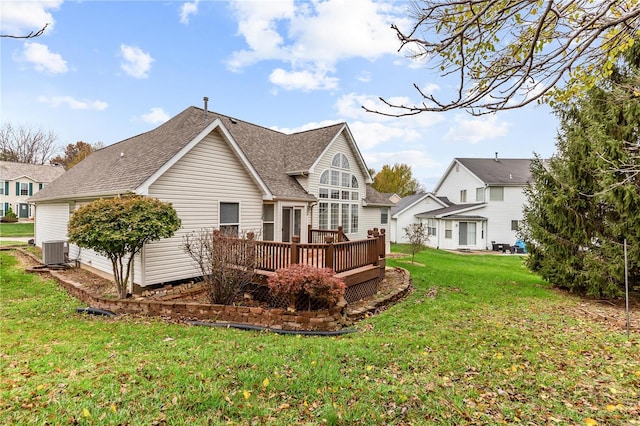 rear view of property featuring a yard, central AC, and a wooden deck