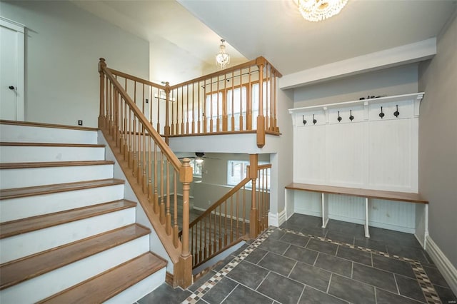 mudroom featuring a chandelier and dark tile patterned floors