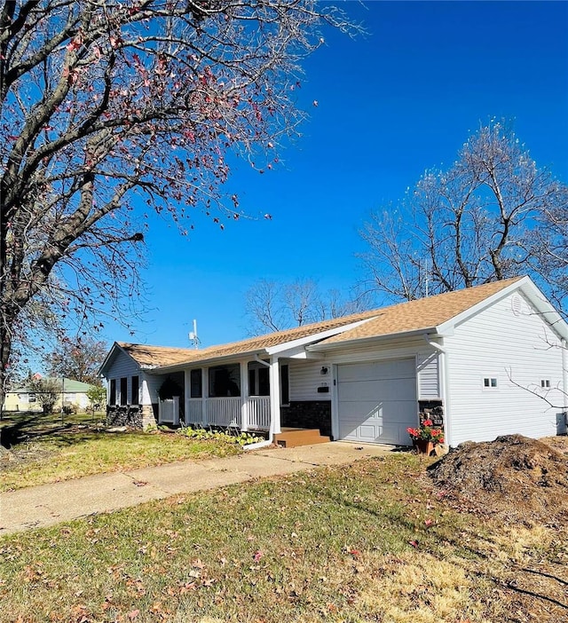 ranch-style home with a porch, a garage, and a front lawn