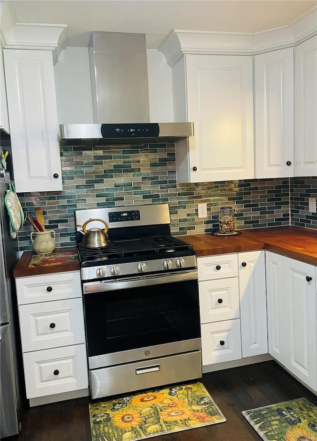 kitchen with dark wood-type flooring, wall chimney range hood, decorative backsplash, butcher block counters, and stainless steel appliances