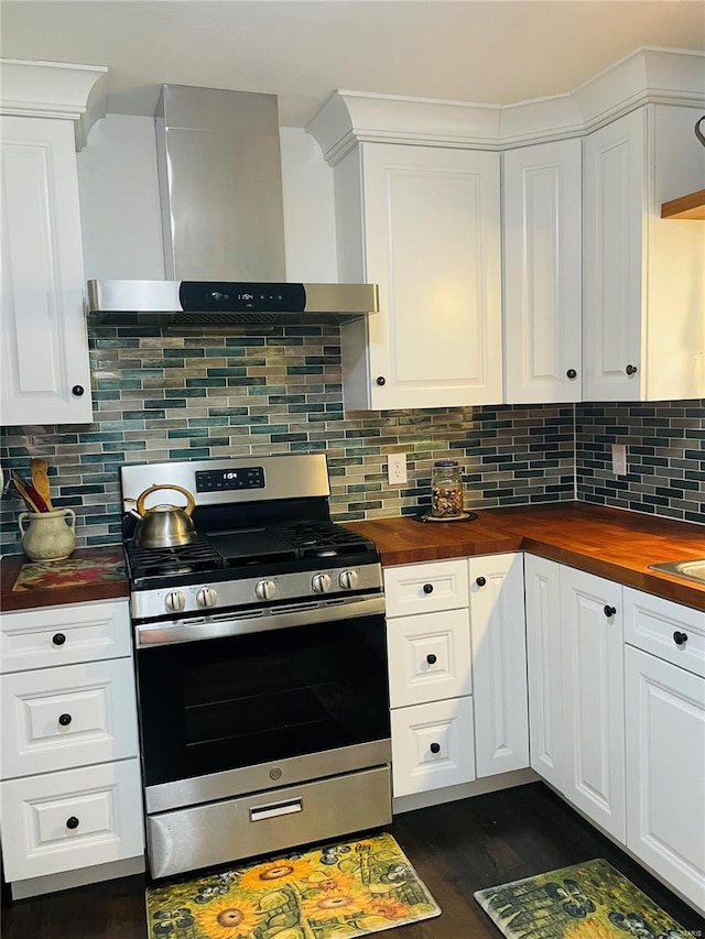 kitchen with backsplash, stainless steel gas range oven, wall chimney exhaust hood, and wood counters