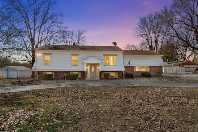 raised ranch featuring brick siding and an outdoor structure